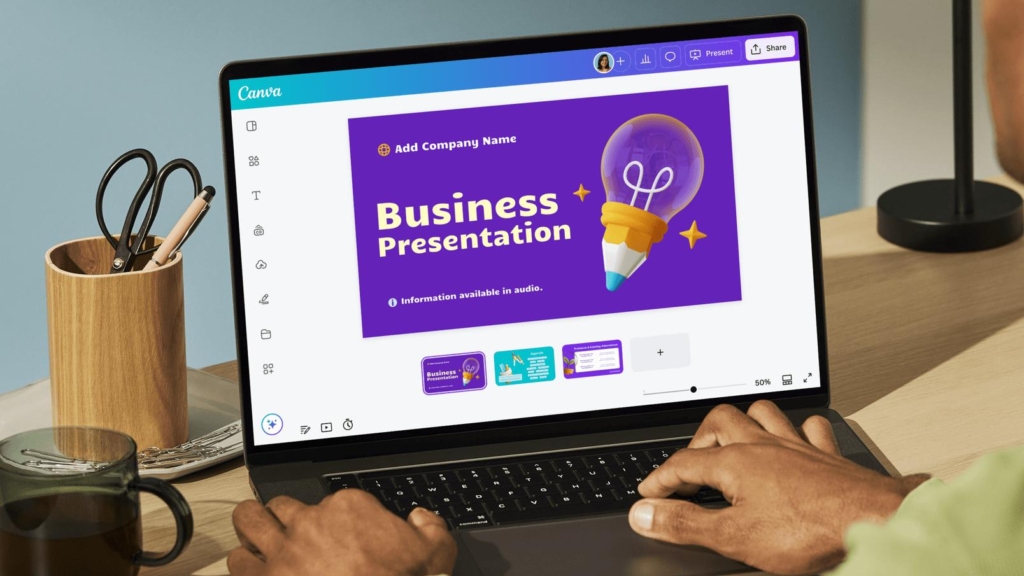 Person creating a business presentation on a laptop using Canva, featuring a purple presentation slide with a light bulb graphic in a modern workspace setting.